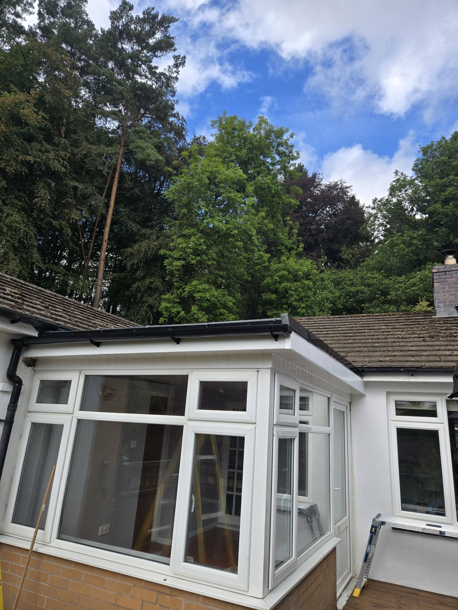 White-framed conservatory with a dark roof