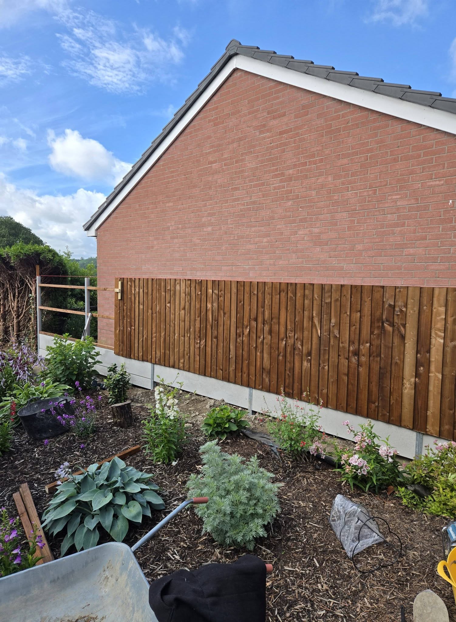 Timber garden fence beside a brick house